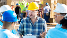 Bauleiter instruiert die Handwerker für ihre Gewerke